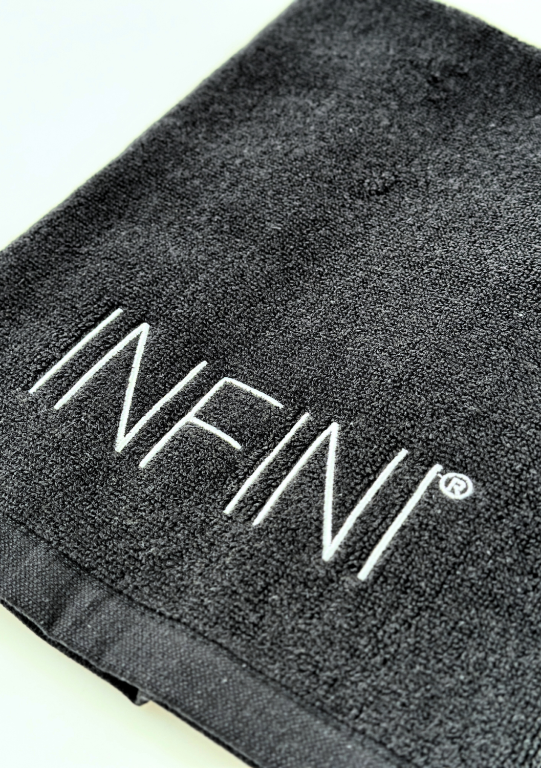 TOWEL INFINI SMALL, BLACK WITH WHITE LOGO 
40x60 cm Kleines Baumwollhandtuch DSD, schwarz mit goldener Stickerei